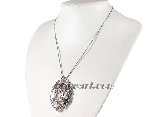 black oval shell pendant with a head statue